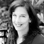 A black and white headshot of a woman smiling for the camera.